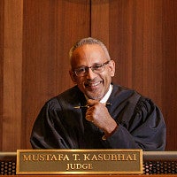 A picture of Judge Mustafa T. Kasubhai in the courtroom.
