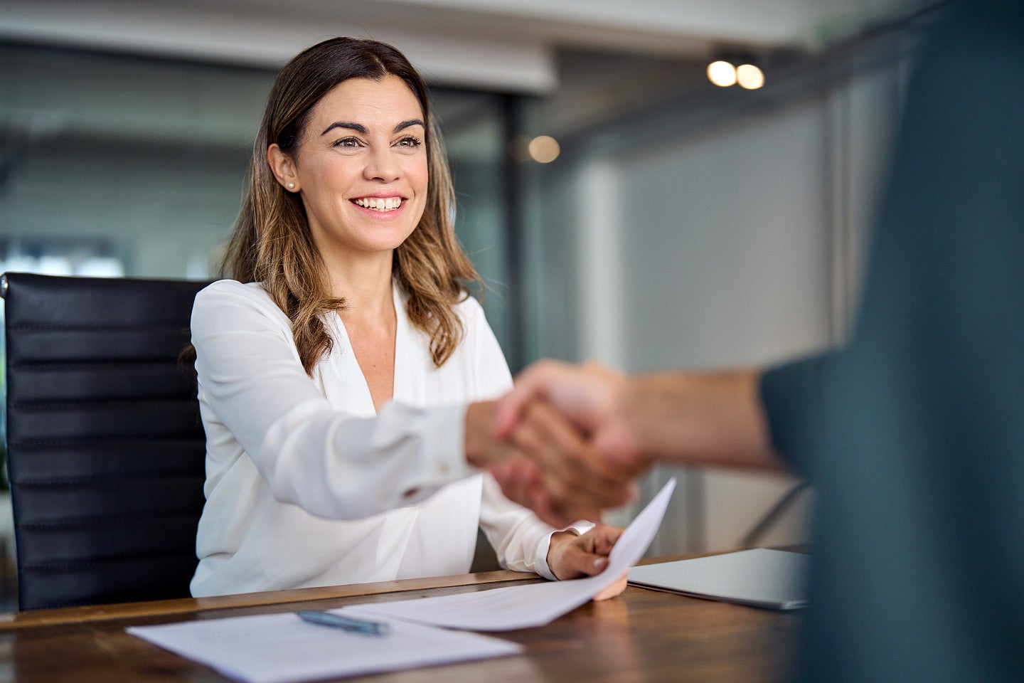 Business attorney smiling and shaking hands with a client