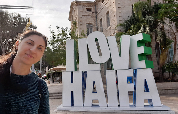 Orli Oren Kolbinger by a sign that says I Love Haifa