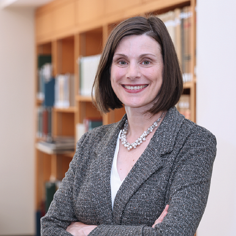 Dean Jennifer W. Reynolds crossing her arms and smiling in front of a book shelf.