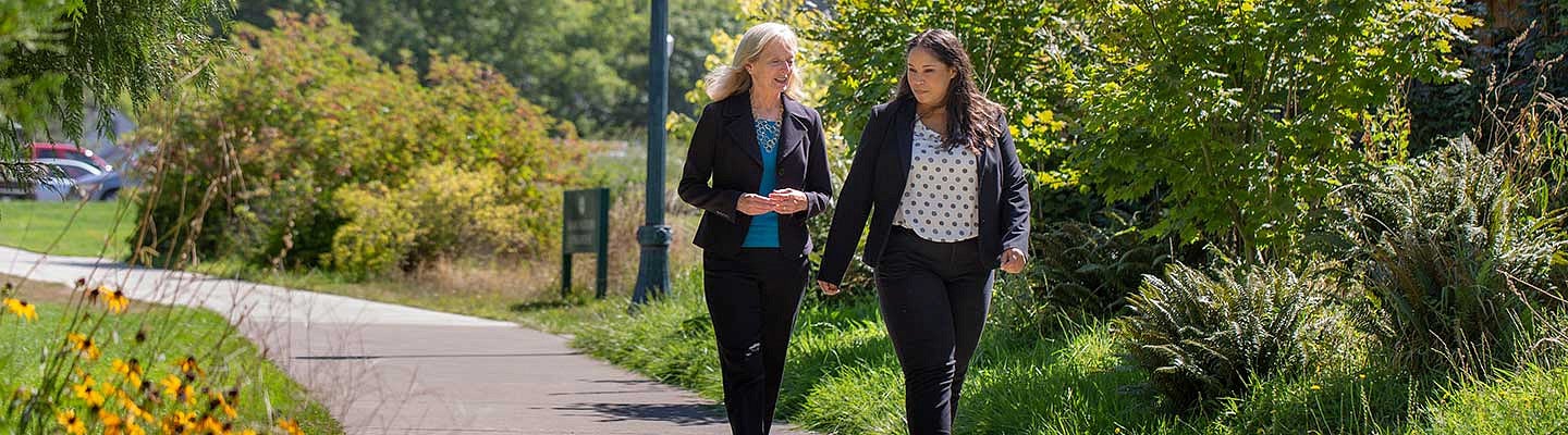 A professor and a student walking near the Law Center building