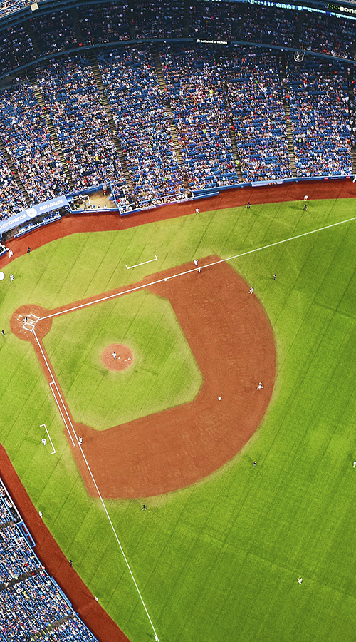 extreme aerial view of a baseball field and stadium at night during a game