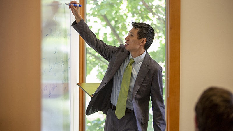 Professor Chinn making notes on a whiteboard as he lectures