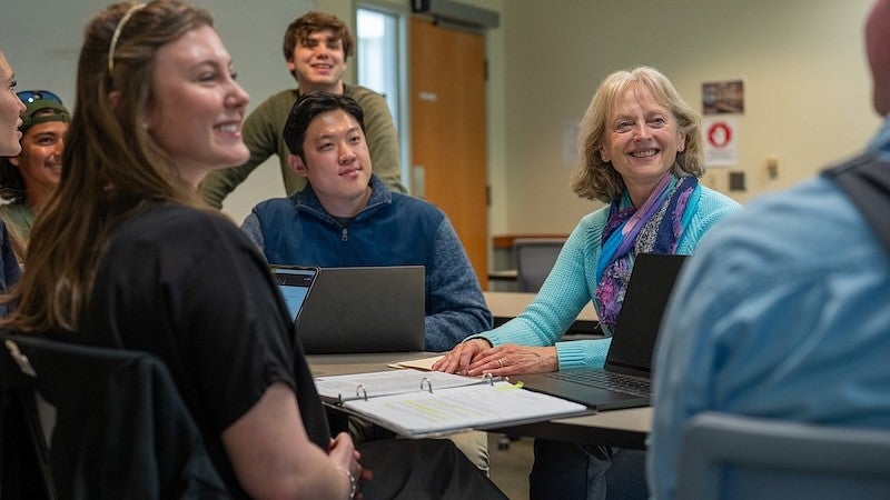 Smiling professor and students.