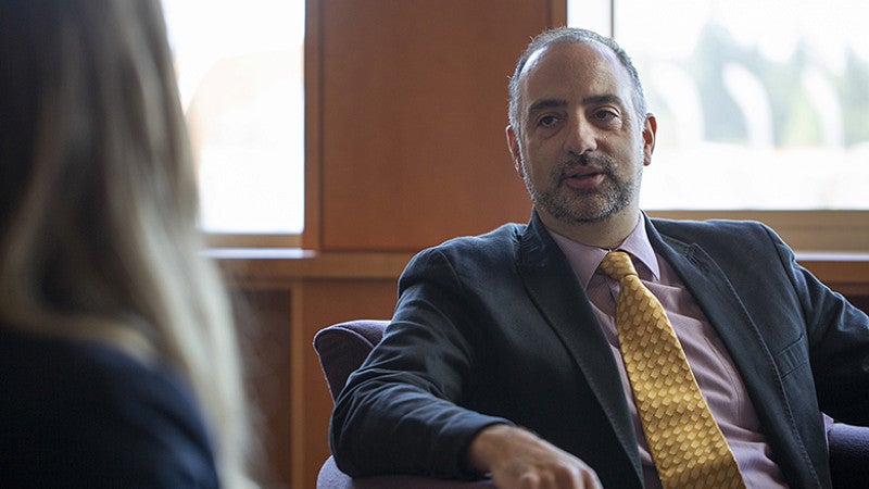 Professor Eric Priest sitting down and talking with a law student