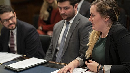 Sierra Waechter JD ’21 presents research on emissions from the transportation sector while her teammates Whit Koch JD ’20 and Jake Miller JD ’20 look on.