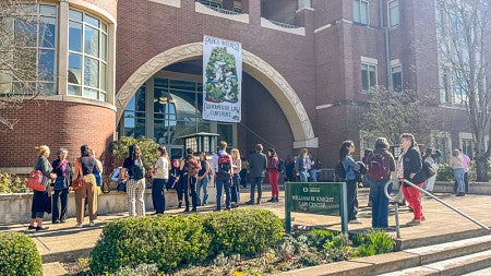People mingle outside the front of the law school at the 2025 PIELC event.