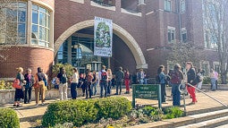 People mingle outside the front of the law school at the 2025 PIELC event.