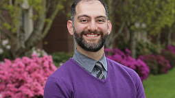 Professor Fakhri smiling with flowers in the background