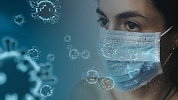 woman wearing a mask with COVID19 virus scattered around photo