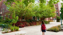 A student walking towards the Knight Law Center building