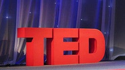 TED in red letters on a stage