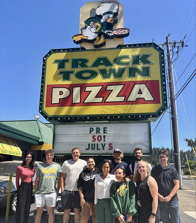 Maureen Weston pictured with 2025 SSLI students at Track Town Pizza
