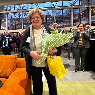 Nan Waller holding a bouquet of flowers while onlookers are clapping