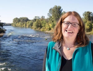 Adell Amos standing in front of the Willamette River