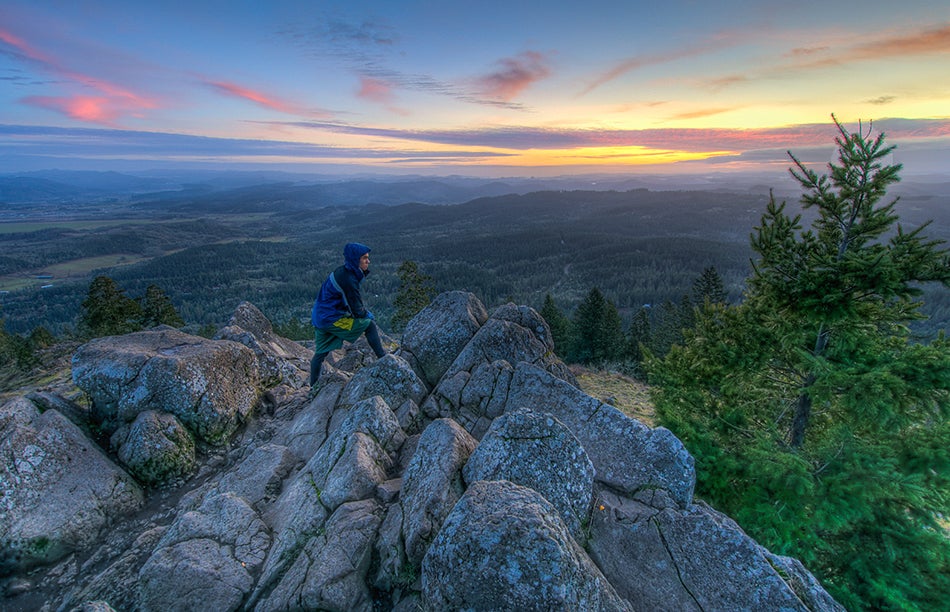 hiker looking out from Spencer&#039;s Butte at sunset