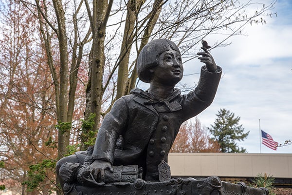 statue of a child paying with a butterfly