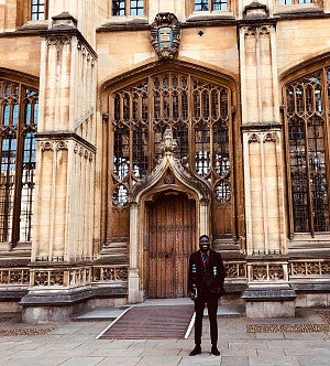 Akinbosade Adedayo outside the Divinity School at Oxford University Akinbosade Adedayo standing in front of an exterior door outside the Divinity School at Oxford University