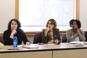 Three students in a row looking attentively off screen