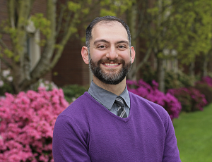 Professor Fakhri smiling with flowers in the background