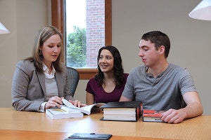 Professor Elizabeth Frost at table with two students