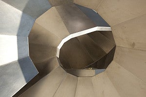 Looking up through the middle of a swirly metallic sculpture