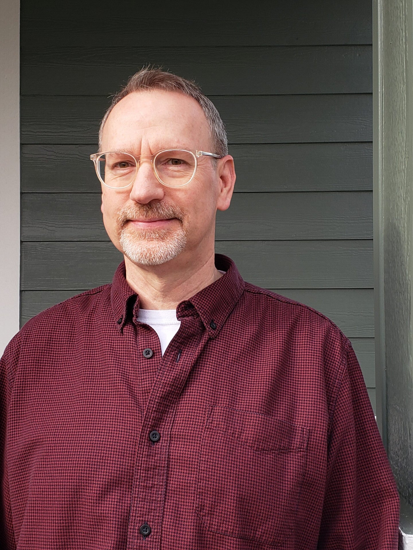 Image of man with glasses and a red button down shirt