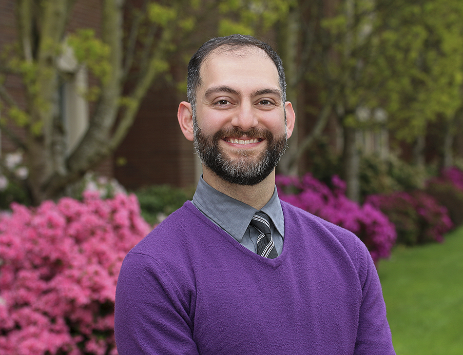 Professor Fakhri smiling with flowers in the background