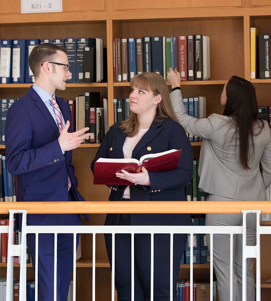 Jaqua Law Library Students in the law library looking over a book