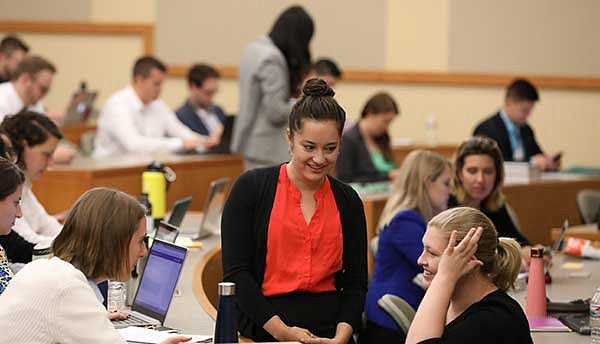 Students sitting in a small group talking in a classroom