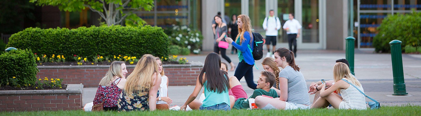 a group of students sitting on the lawn