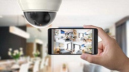 A high tech camera with a smartphone showing video surveilance