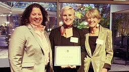 Camille Krier holding her award with Chief Justice Martha Walters and Oregon State Bar President Christine R. Constantino