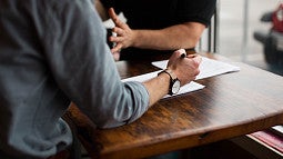 Two people at a table talking